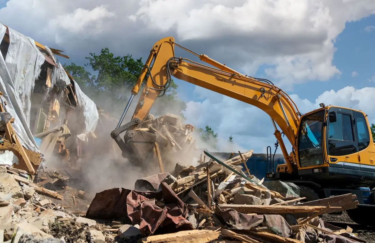 Excavator tearing down a structure and sorting the scrap