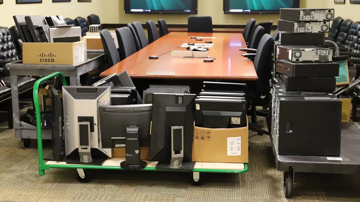 Surplus office and IT equipment staged on carts for liquidation
