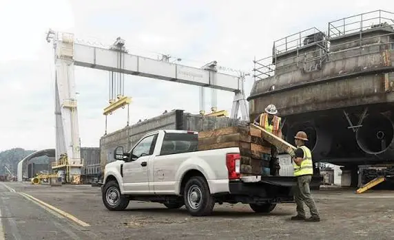 Crew loading scrap onto a pickup truck at an industrial site